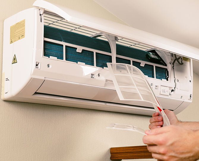 HVAC Services Pro technician servicing a ductless mini-split air conditioner to ensure reliable home cooling.